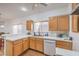 Efficient kitchen with wood cabinets, white countertops, updated appliances, and plenty of natural light at 3735 Morning Canyon St, Las Vegas, NV 89147