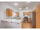 Well-lit kitchen with stainless steel appliances, white countertops, wood cabinets and ceiling fan at 3735 Morning Canyon St, Las Vegas, NV 89147