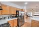 Kitchen featuring stainless steel appliances and wood cabinets, flowing seamlessly into the dining and living spaces at 3735 Morning Canyon St, Las Vegas, NV 89147