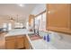 Well-lit kitchen area with a sink, wooden cabinets, white tile countertops, and a view to the living room at 3735 Morning Canyon St, Las Vegas, NV 89147