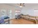 Bright living room features wood floors, a comfortable sofa, a ceiling fan, and glass doors to the outside patio at 3735 Morning Canyon St, Las Vegas, NV 89147