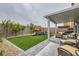 Beautiful backyard with a covered patio, artificial grass, and play structure perfect for entertaining at 3903 Ramura Ave, North Las Vegas, NV 89084