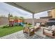 Charming backyard with pavers, artificial grass, a covered patio and play structure at 3903 Ramura Ave, North Las Vegas, NV 89084