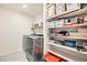 Well-organized laundry room with shelving, washer, and dryer for efficient cleaning at 3903 Ramura Ave, North Las Vegas, NV 89084