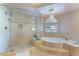 Bright bathroom featuring a glass shower, soaking tub, and chandelier for a luxurious spa-like experience at 3921 White Castle St, Las Vegas, NV 89129
