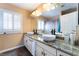 Well-lit bathroom with dual vessel sinks, granite countertop, modern lighting, and a large framed mirror at 3921 White Castle St, Las Vegas, NV 89129