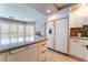 Bright kitchen boasts granite counters, white cabinets, stainless appliances, and island seating at 3921 White Castle St, Las Vegas, NV 89129