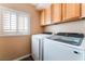 Well-lit laundry room features wood cabinets and a front-loading washer and dryer at 3921 White Castle St, Las Vegas, NV 89129