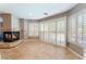 Cozy living room with fireplace and large windows featuring white shutters, allowing ample natural light at 3921 White Castle St, Las Vegas, NV 89129