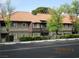 Exterior shot of a two story building with a orange tile roof and black metal fence surrounded by green trees and bushes at 5038 S Rainbow Blvd # 206, Las Vegas, NV 89118