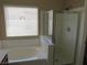 A bright bathroom features a soaking tub and a glass enclosed shower at 5240 Sweet William St, North Las Vegas, NV 89081
