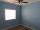 Bedroom with ceiling fan, laminate floors, and a window at 5240 Sweet William St, North Las Vegas, NV 89081