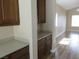 Partial view of a kitchen featuring light-colored countertops, dark wood cabinets, and laminate flooring at 5240 Sweet William St, North Las Vegas, NV 89081
