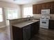 View of kitchen featuring white appliances, wood cabinets, and breakfast bar at 5240 Sweet William St, North Las Vegas, NV 89081