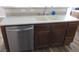 Kitchen sink with dark wood cabinets and stainless steel dishwasher at 5240 Sweet William St, North Las Vegas, NV 89081