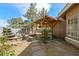 A backyard with an outdoor table and seating area, as well as a custom stone waterfall feature at 5481 Lincolnwood Ct, Pahrump, NV 89061