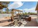 Backyard patio area featuring a pergola, outdoor seating, and desert landscaping at 5481 Lincolnwood Ct, Pahrump, NV 89061