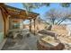 A backyard with an outdoor table and seating area, as well as a custom stone waterfall feature at 5481 Lincolnwood Ct, Pahrump, NV 89061