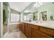 Bright bathroom with double sinks, a large mirror, and a separate tub at 5481 Lincolnwood Ct, Pahrump, NV 89061