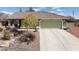 Beautiful home with a green garage door, tile roof, desert landscaping, and a long drive way at 5481 Lincolnwood Ct, Pahrump, NV 89061