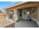 View of the front entrance with stone pillars, a white security door, and desert landscaping at 5481 Lincolnwood Ct, Pahrump, NV 89061