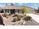 Landscaped front yard featuring desert landscaping, a light brown exterior, and a tile roof under a bright, blue sky at 5481 Lincolnwood Ct, Pahrump, NV 89061