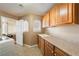 Well-lit laundry room with a sink, ample countertop space, and oak cabinets at 5481 Lincolnwood Ct, Pahrump, NV 89061