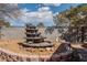 Landscaped backyard featuring a stone fountain and surrounding rock garden, creating a serene outdoor space at 5481 Lincolnwood Ct, Pahrump, NV 89061
