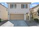 Two-story home featuring an attached garage, arched entryway, and low-maintenance landscaping at 5667 Foxglove Field St, Las Vegas, NV 89130
