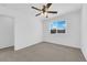 This empty bedroom features a ceiling fan, neutral carpet, light walls, and a window with blinds at 5846 Bonita Rose St, Las Vegas, NV 89113