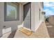 A gray front door with a welcome mat sits on a stone porch, next to a wall with small stones at 5846 Bonita Rose St, Las Vegas, NV 89113
