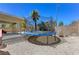 This backyard features a trampoline, patio, rock landscaping and block wall at 6013 Aqua Blue Ct, North Las Vegas, NV 89031