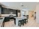 Well-equipped kitchen featuring dark cabinetry, stainless steel appliances, and a center island with bar stools at 6338 Selston Dr, North Las Vegas, NV 89081