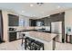 Modern kitchen with dark cabinets, stainless steel appliances, and a spacious island with seating at 6338 Selston Dr, North Las Vegas, NV 89081