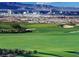 Picturesque golf course with views of a city skyline and mountains in the background at 650 Scenic Cliff Dr, Henderson, NV 89012