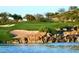 Picturesque golf course view with a waterfall flowing into a lake, sandy bunkers, and greenery at 650 Scenic Cliff Dr, Henderson, NV 89012