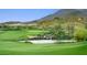 Scenic golf course with water feature, lush greenery, and mountain views, ideal for leisure at 650 Scenic Cliff Dr, Henderson, NV 89012