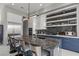 Kitchen island with barstool seating, stainless steel refrigerator, and modern decor at 650 Scenic Cliff Dr, Henderson, NV 89012