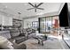 Spacious living room featuring an oversized sofa, modern decor, and seamless indoor/outdoor flow at 650 Scenic Cliff Dr, Henderson, NV 89012