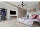 Spacious main bedroom features stylish decor, a modern ceiling fan, and a large tv and shelving at 650 Scenic Cliff Dr, Henderson, NV 89012