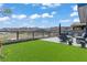 Relaxing outdoor patio featuring lush synthetic grass, comfortable seating and mountain views at 650 Scenic Cliff Dr, Henderson, NV 89012
