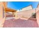 Enclosed backyard featuring a covered patio, low-maintenance gravel landscaping, and block wall for privacy at 7012 Mercurio Ave, Las Vegas, NV 89131