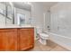 Bright bathroom with a wood vanity, white toilet, and a combined tub and shower with white tile at 7012 Mercurio Ave, Las Vegas, NV 89131