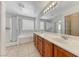 Bathroom featuring double vanity, large mirror, soaking tub and glass shower at 7012 Mercurio Ave, Las Vegas, NV 89131