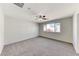 Light-filled bedroom with neutral carpet, a ceiling fan, and neighborhood views at 7012 Mercurio Ave, Las Vegas, NV 89131