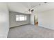 Large bedroom with neutral carpet, a ceiling fan and an ensuite bathroom at 7012 Mercurio Ave, Las Vegas, NV 89131