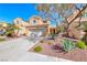 Inviting two-story home featuring a well-maintained front yard with desert plants, set against a bright blue sky at 7012 Mercurio Ave, Las Vegas, NV 89131
