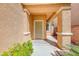 A cozy covered front porch offering a shaded entryway, enhanced by desert foliage and textured exterior walls at 7012 Mercurio Ave, Las Vegas, NV 89131
