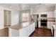 Bright kitchen with stainless steel appliances, light countertops, island, and hardwood floors at 7012 Mercurio Ave, Las Vegas, NV 89131