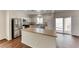 Bright kitchen features stainless steel appliances, light countertops, island, and sliding glass door at 7012 Mercurio Ave, Las Vegas, NV 89131
